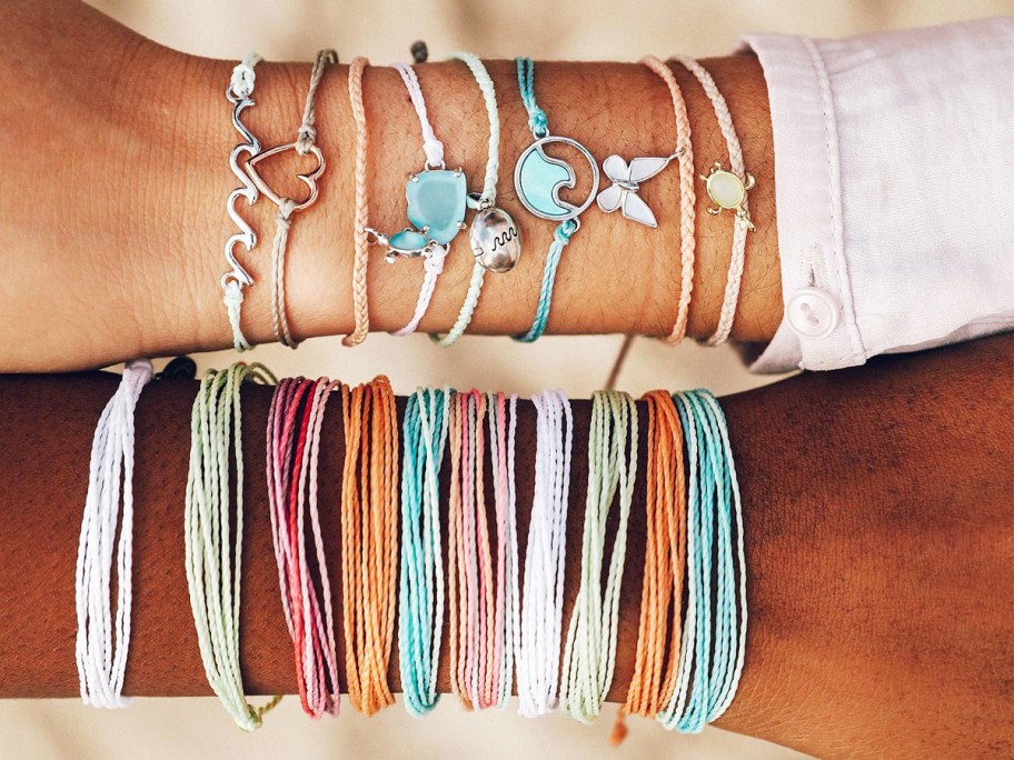 two arms covered in bracelets