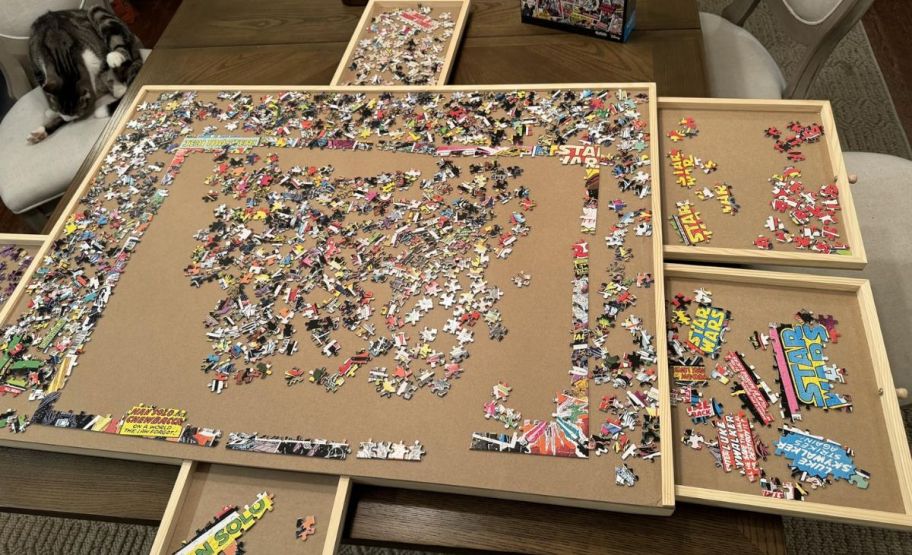 a rotating puzzle table is shown with open draws and a puzzle being assembled.