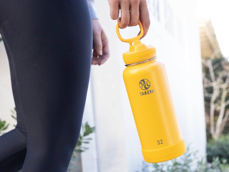 woman holding an orange water bottle