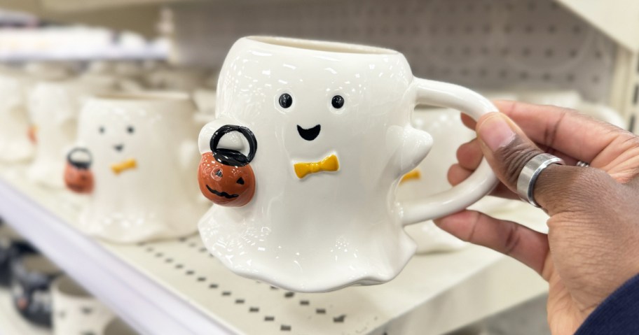 hand holding up a ghost shaped coffee mug in store