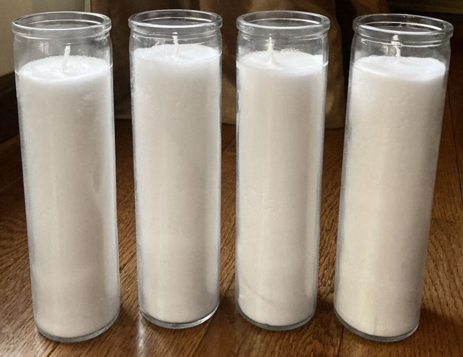 a 3 tall white jar candles in a row