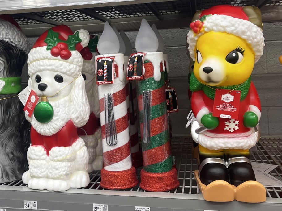 poodle, candles, and skiing reindeer christmas blow molds on store shelf