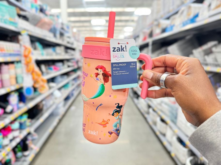 A person holding up a small Princess tumbler in the store