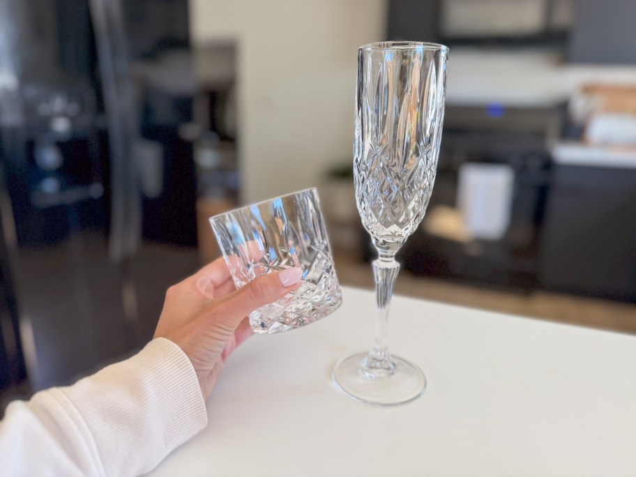 hand holding crystal glasses on countertop