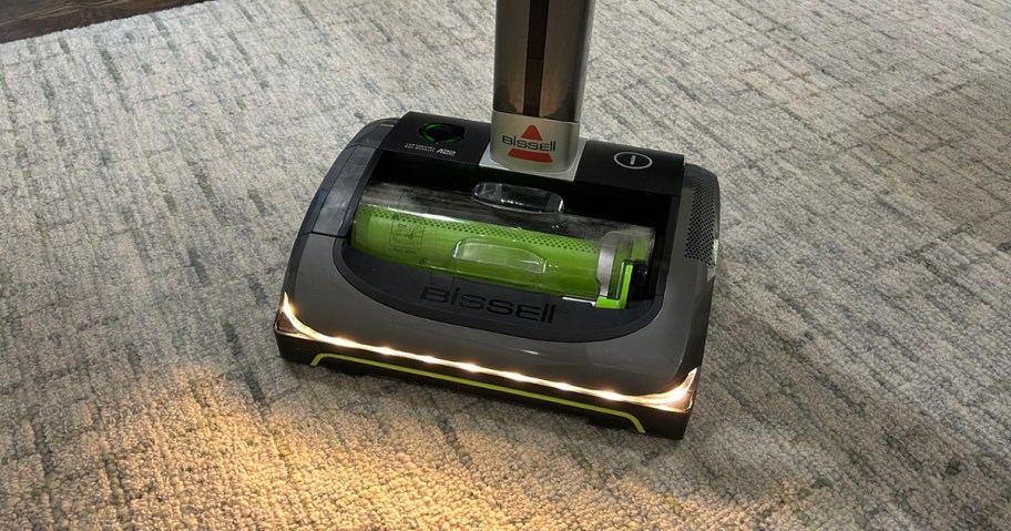 green and gray airram vacuum on rug with lights