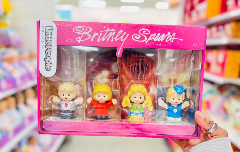 a woman hand holding a box of Britney Spears little people in a target store