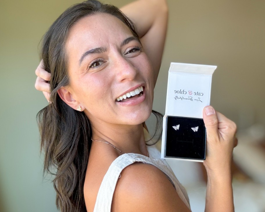 woman holding butterfly earrings in box