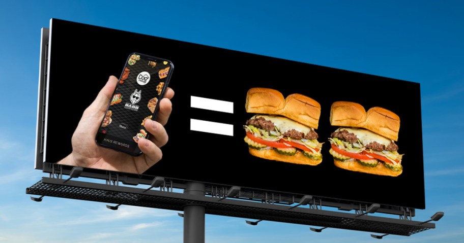 billboard showing phone and 2 cheeseburgers on a black background