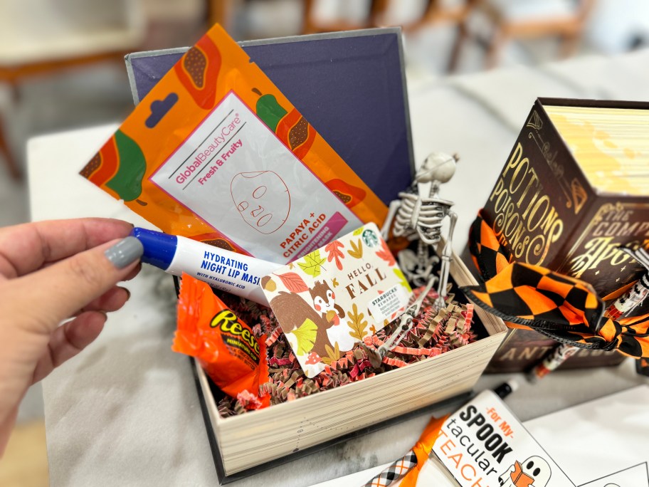 filling halloween gift box with small presents