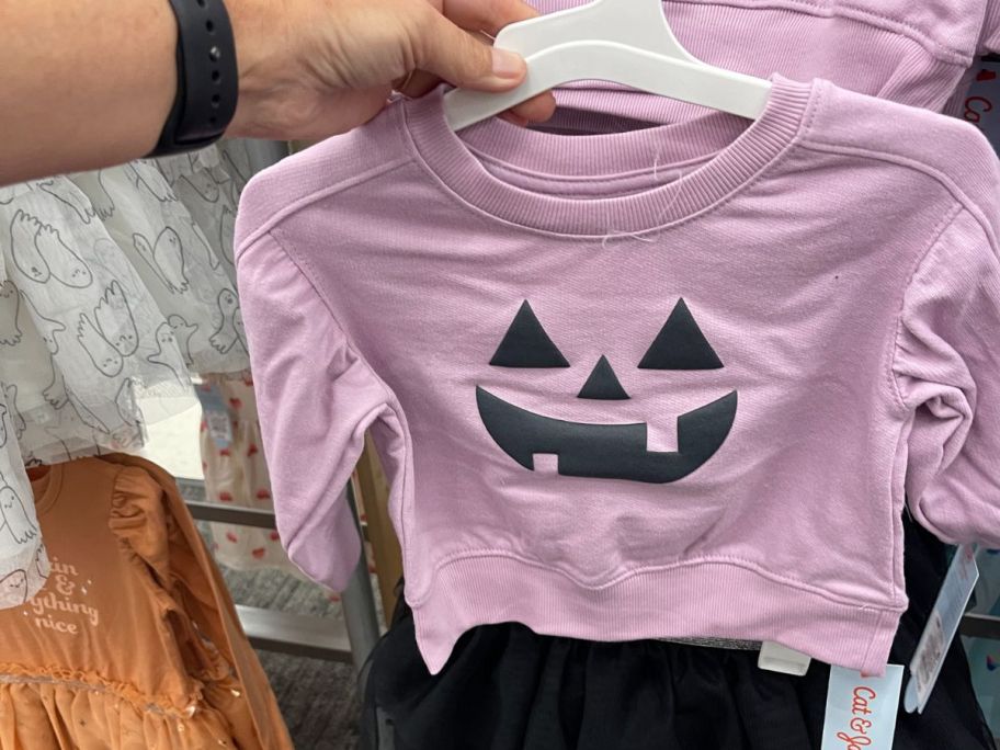 purple Cat & Jack Pumpkin Shirt in hand in store