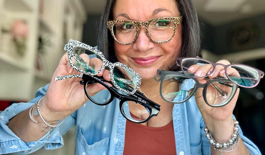 woman holding up several pairs of kits glasses