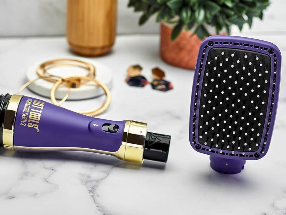 purple and gold paddle straightener with attachment off on table