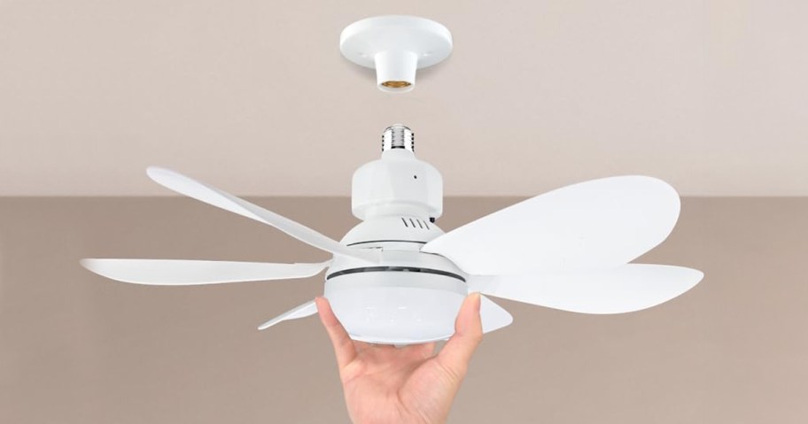 hand putting white socket fan on ceiling