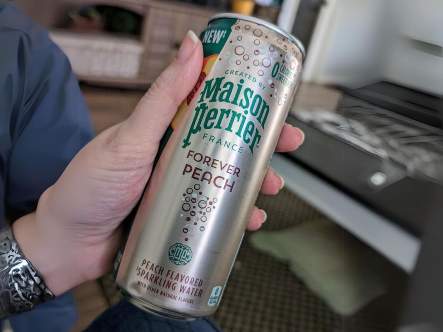 hand holding Maison Perrier Flavored Sparkling Water can in hand