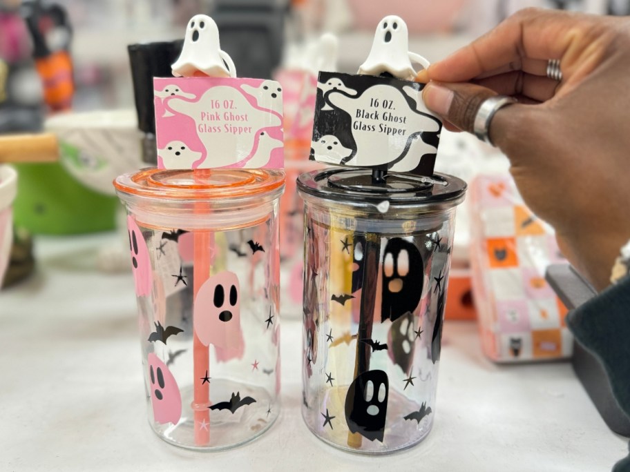 hand reaching glass ghost tumblers with bamboo tops and straws