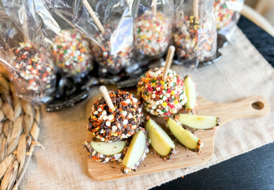 sliced apples displayed in front of decorated caramel apples both in and out of the packaging