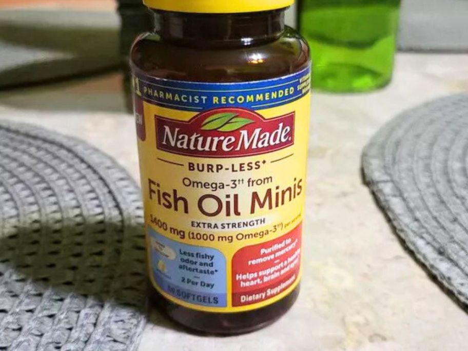 a Nature Made Fish Oil Minis 60-Count bottle on table in between two place mats