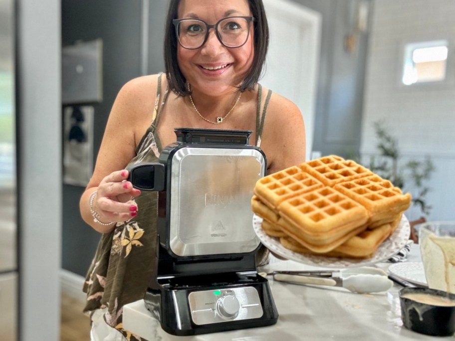 lina holding plate of waffles next to waffle maker