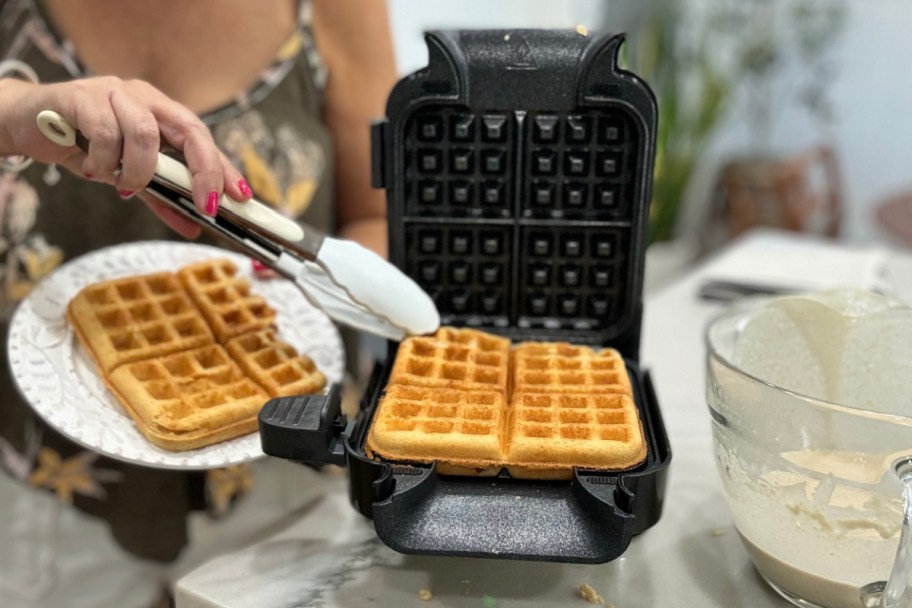 tongs grabbing waffle off waffle maker