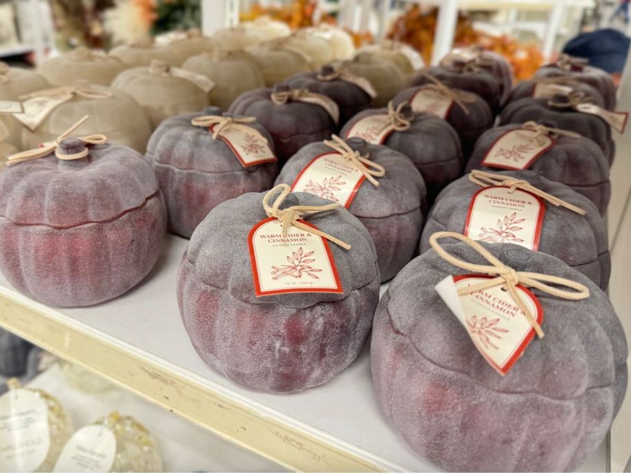 red pumpkin candle sitting on shelf