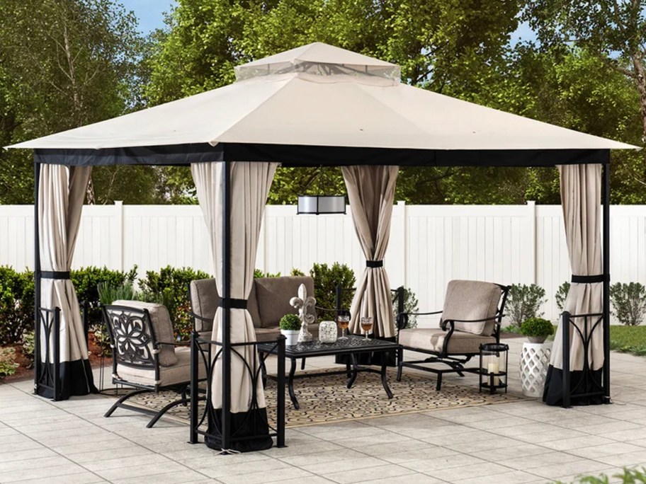 tan and black gazebo outdoors with patio set underneath