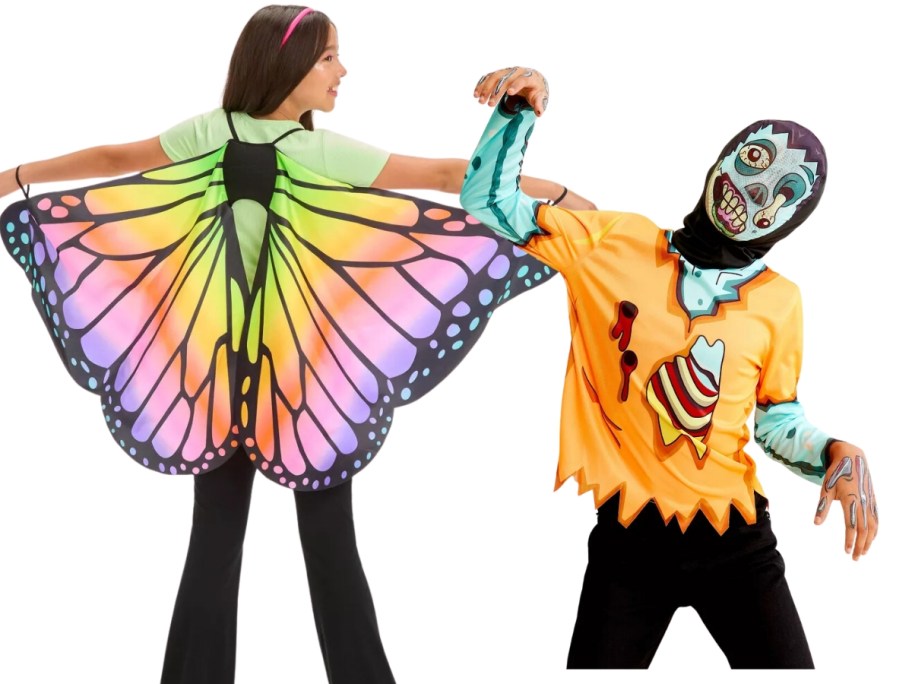 girl wearing colorful butterfly wing costume with her back to the camera, boy wearing a Zombie shirt and mask costume