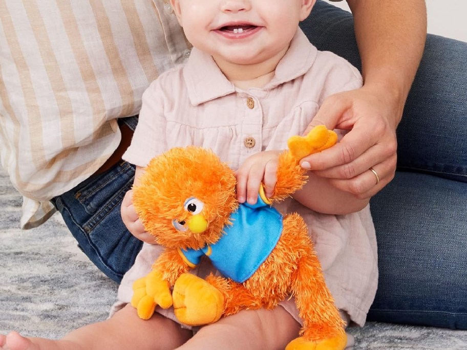 toddler playing with herbie doll