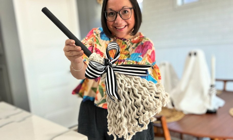 woman holding a witch broom plunger