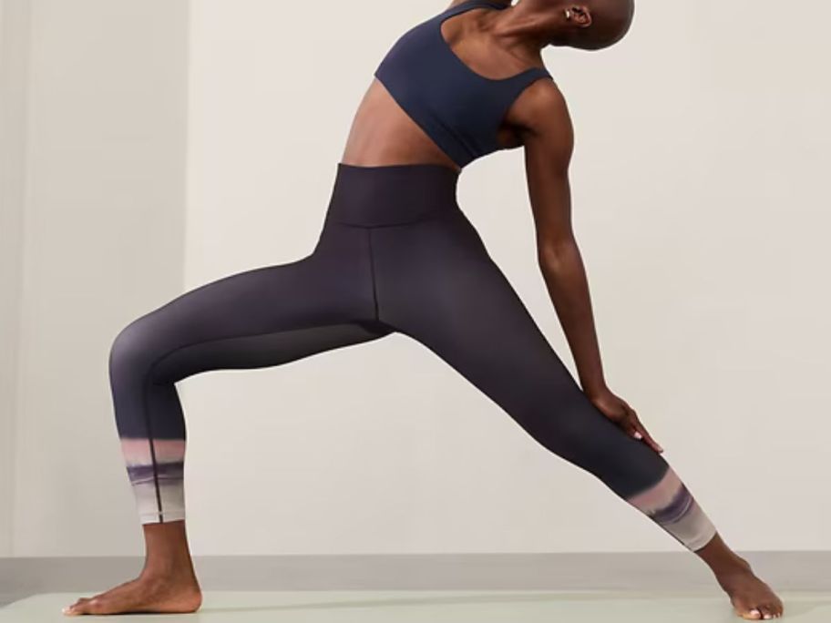 Woman doing yoga wearing Athleta Elation High Rise 7/8 Leggings 