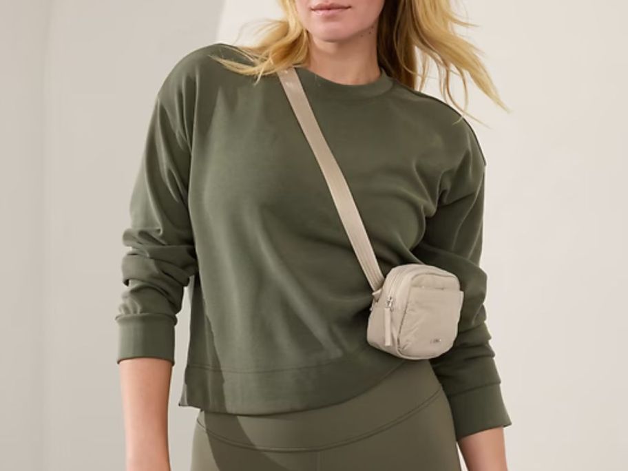 woman wearing a Athleta Seasoft Crewneck Sweatshirt with abelt bag