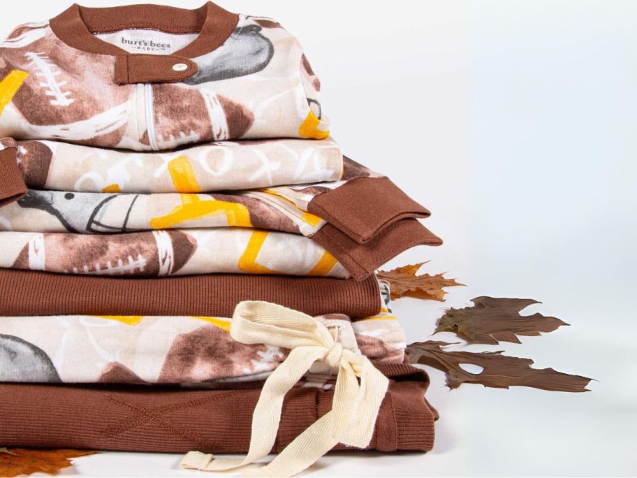 Burt's Bees Baby Football Season Organic Matching Family Pajamas stacked next to fallen leaves