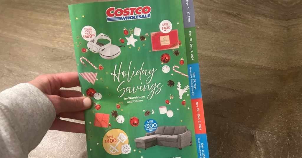 person holding costco savings booklet