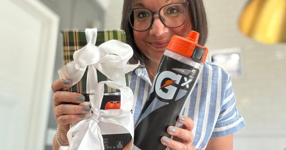 Woman holding a personalized Gatorade GX Water Bottle and two boxes of pods with ribbon on them