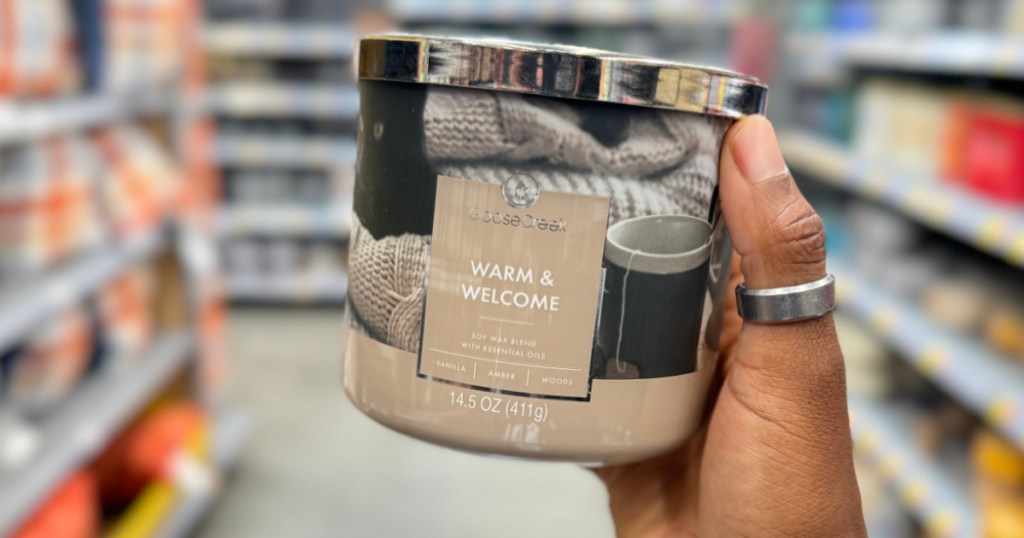 person holding up GooseCreek Warm Welcome Candle in walmart