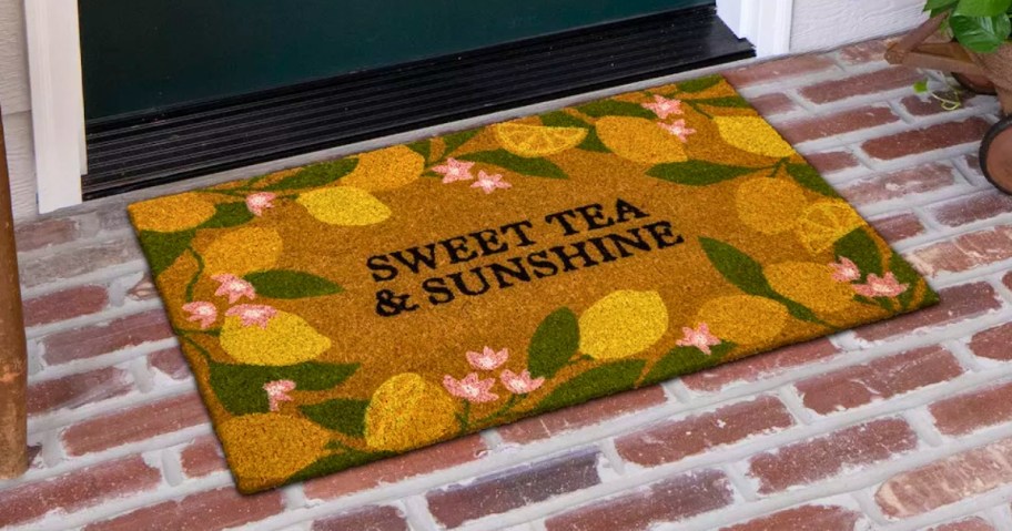 a coir doormat with lemons and flowers in front of a door