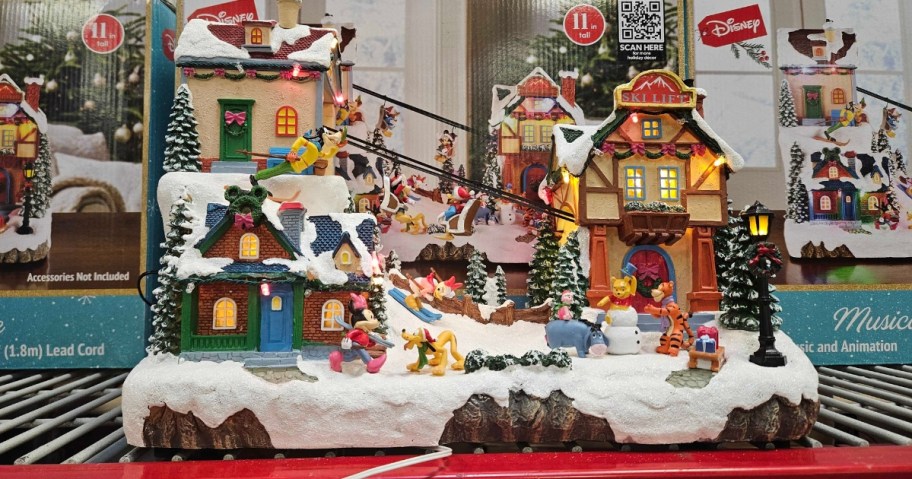 a Disney Christmas Village piece with Mickey and friends on a ski trip sitting on a shelf at Sam's Club