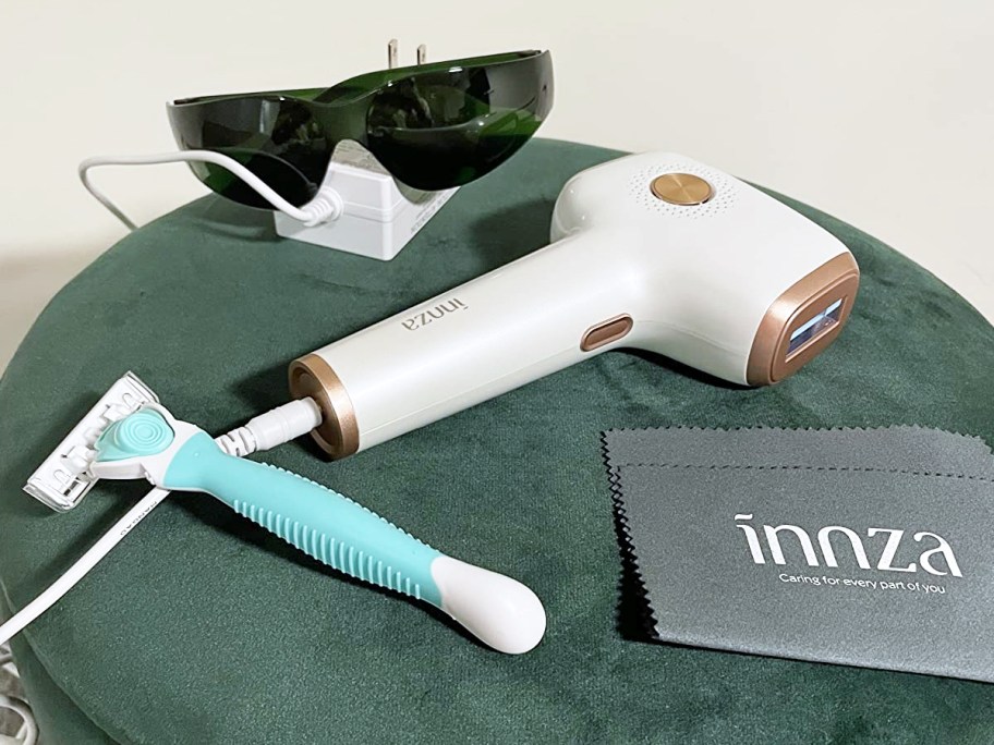 ipl device, razor, and sunglasses on ottoman