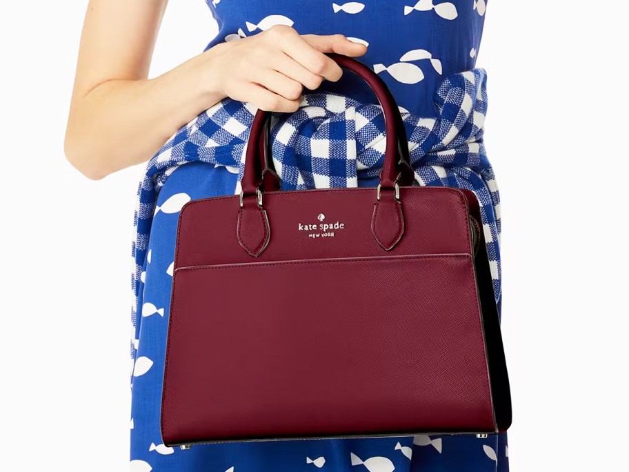 woman in a blue dress with a maroon handbag