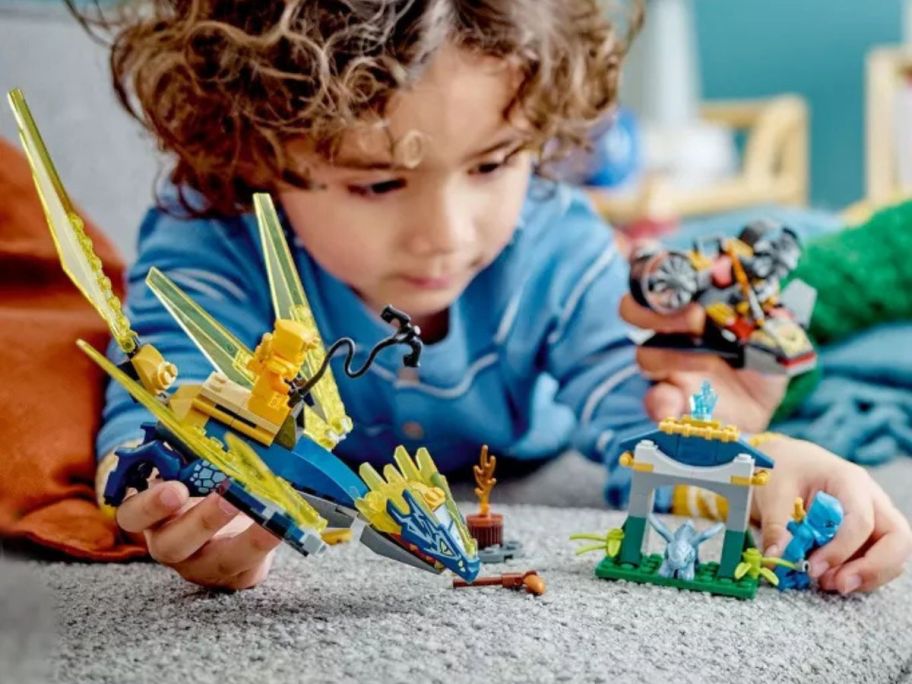 kid playing with LEGO NINJAGO Nya & Arin's Baby Dragon Battle Building Toy