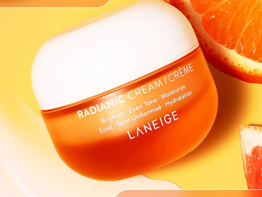 orange jar of Laneige Radian-C Cream near sliced oranges