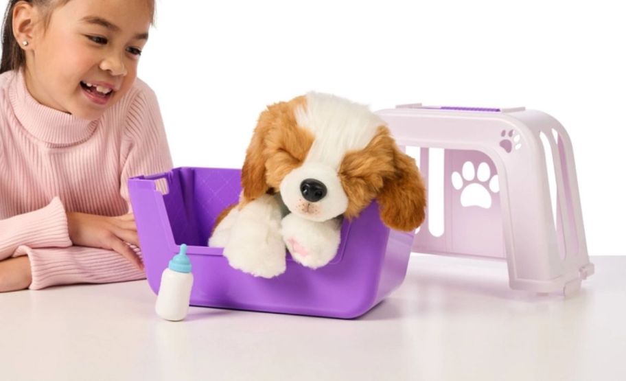 a little girl playing with a toy puppy