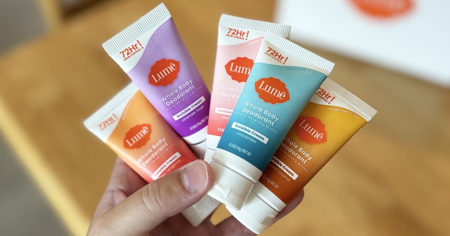 hand holding up 5 mini tubes of Lume Whole Body Deodorant