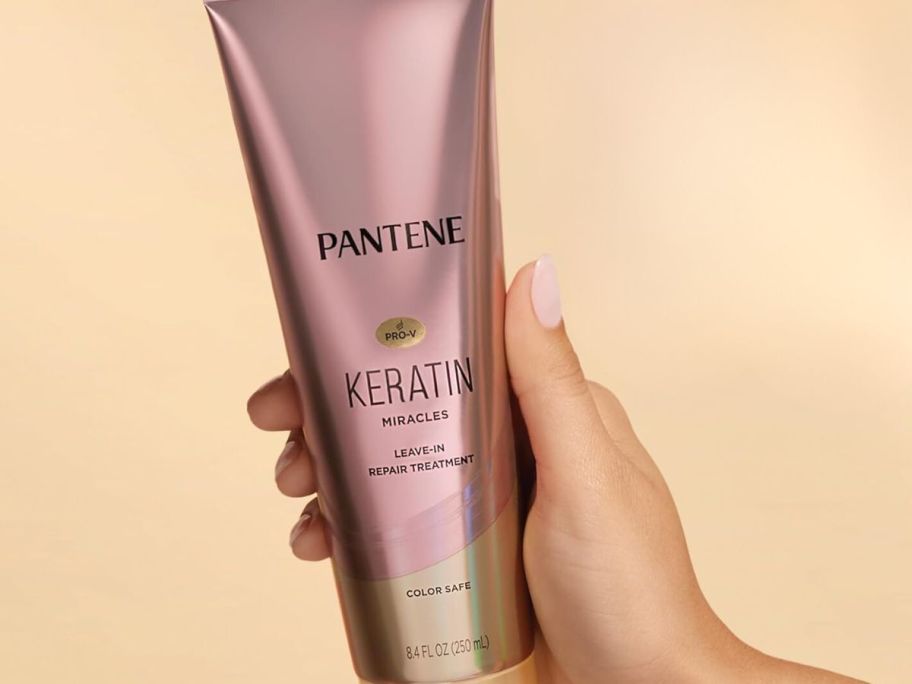 A person holding a Pantene Keratin Miracles Leave-In Treatment