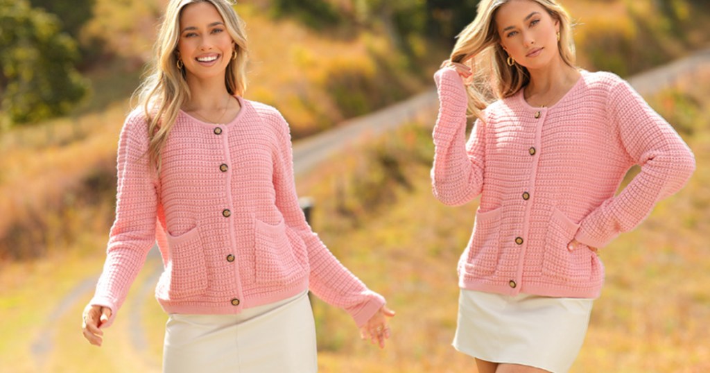 girl wearing pink cardigan and standing outside in field