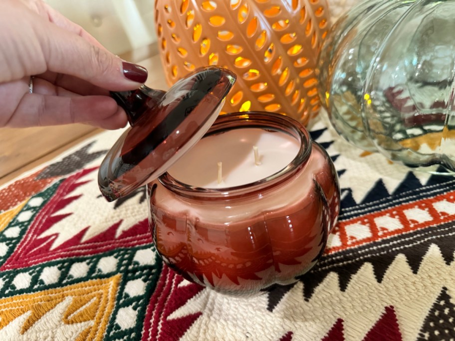 Hand opening a Pumpkin Candle from Walmart