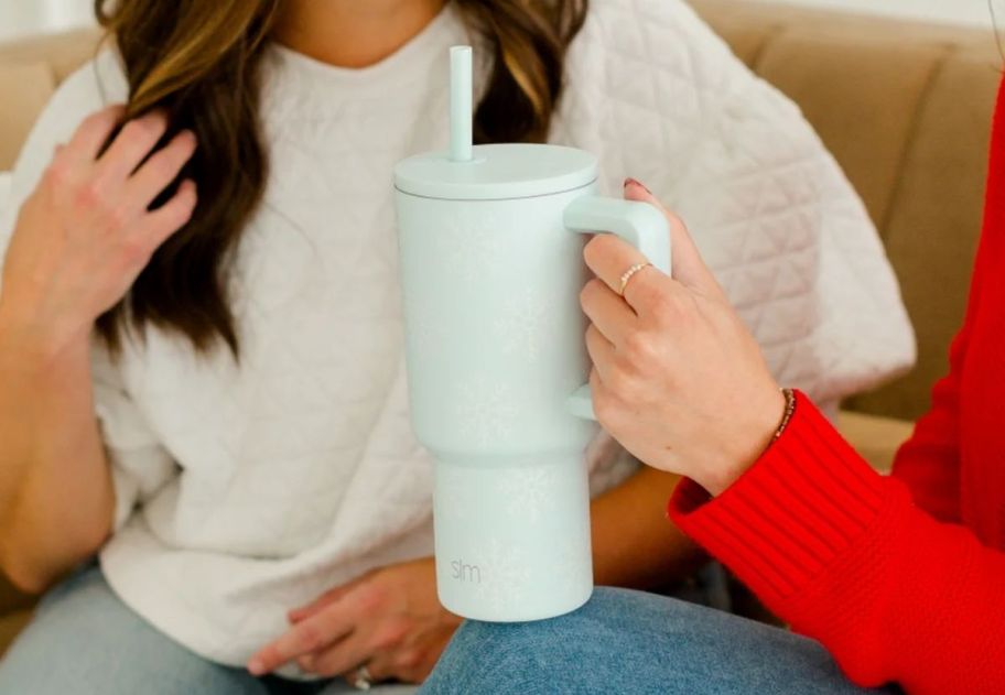 a womans hand holding a snowflake print simple modern 30oz tumbler