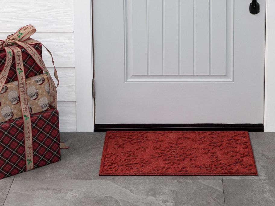 a red snowflake embossed doormat in front of a door