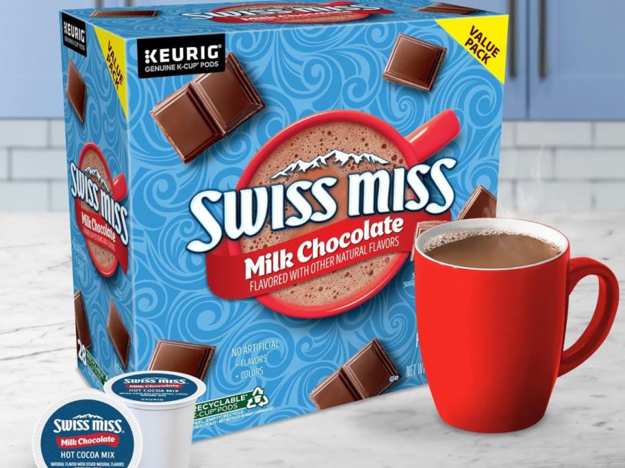 A box of Swiss Miss Hot cocoa k-cups next to a mug full of hot cocoa