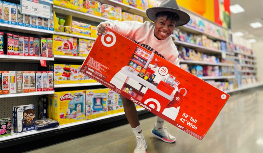 woman holding a Target Checklane toy box in-store