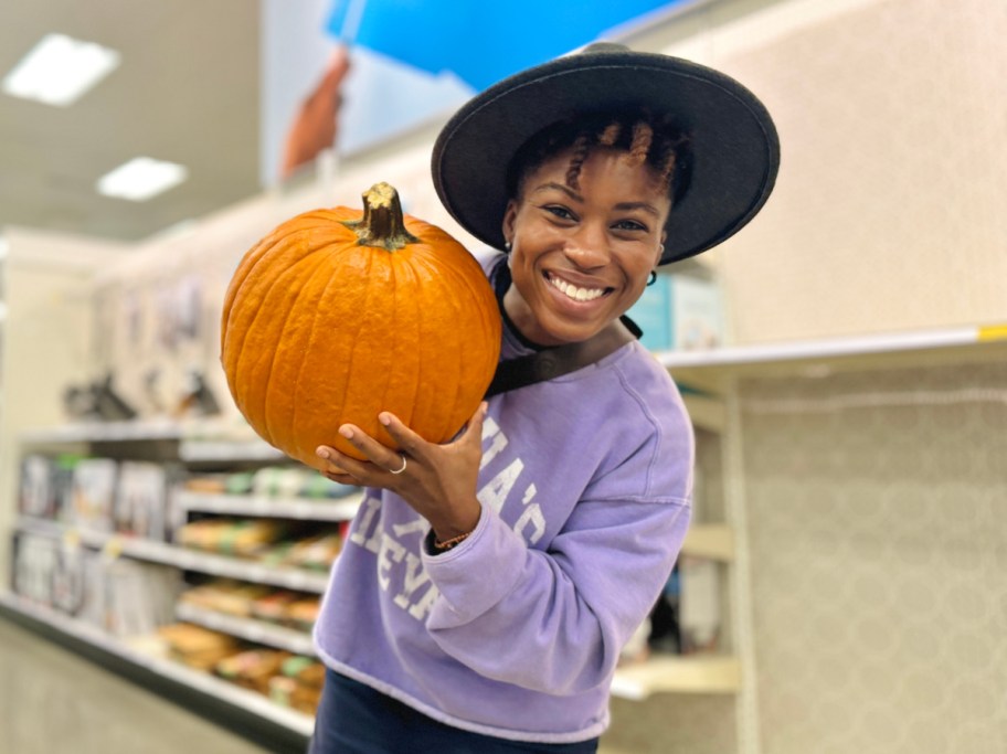 Woman holding up a pumpkin from Target